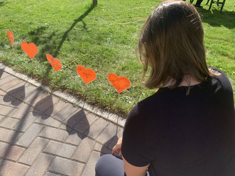 Someone reading message to residential school survivors at the 2024 heart garden in Buller greenspace at UM