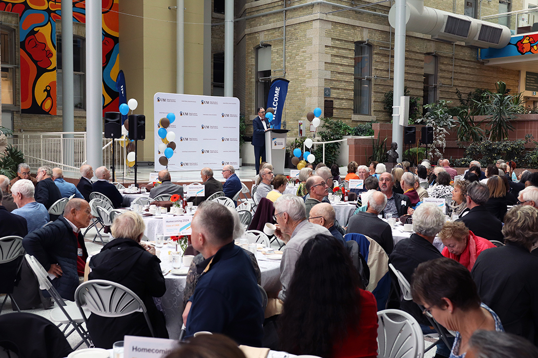 Dr. Peter Nickerson speaks to a large crowd gathered in the Brodie Centre atrium at Bannatyne campus.