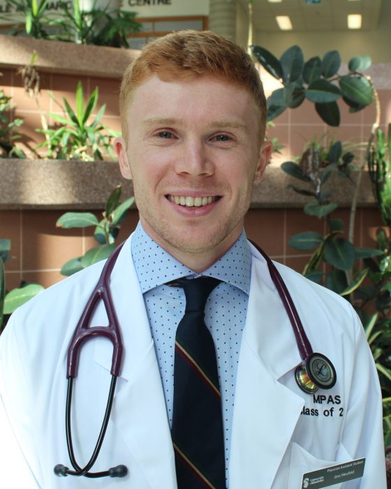 Portrait of Jess Neufeld. He is wearing a white coat and a stethoscope. 