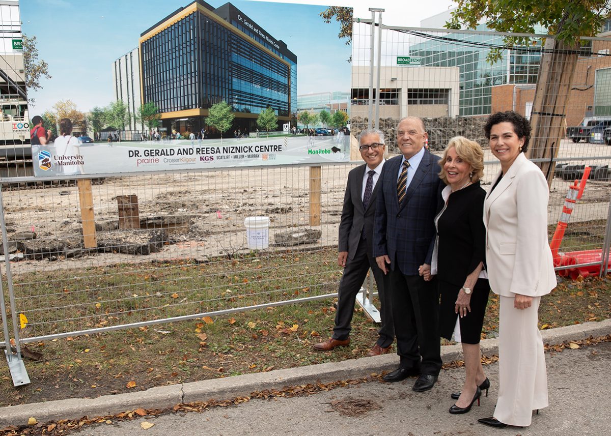 President Benarroch, the Niznicks and Dr. Anastasia Kelekis-Cholakis standing at the construction site next to a poster with the rendering of the new Dr. Gerald and Reesa Niznick Centre.