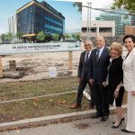 President Benarroch, the Niznicks and Dr. Anastasia Kelekis-Cholakis standing at the construction site next to a poster with the rendering of the new Dr. Gerald and Reesa Niznick Centre.