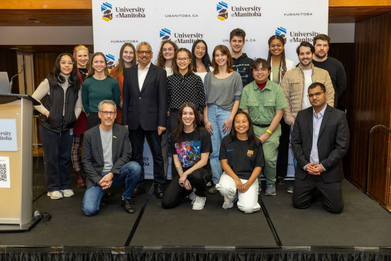 Winners of the 2024 Undergraduate Research Showcase stand and kneel together smiling.