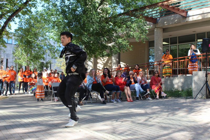 A person dances in front of a crowd. 