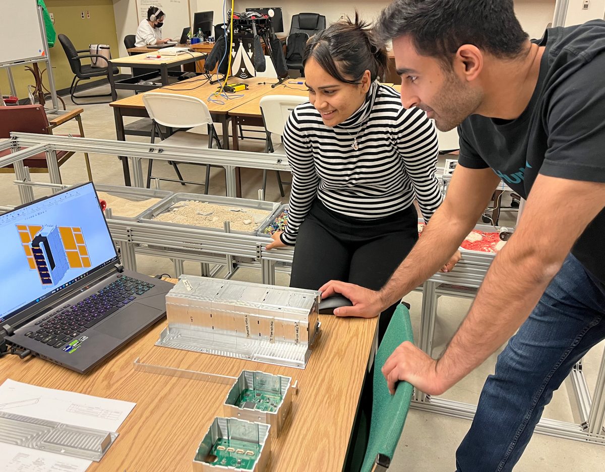 students looking at computer screen with model in front of them