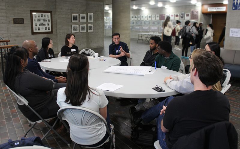 A group of students around a tablein a discussion.