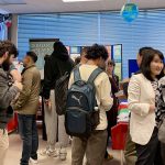 A group of students and instructors going booth to booth at an information fair.