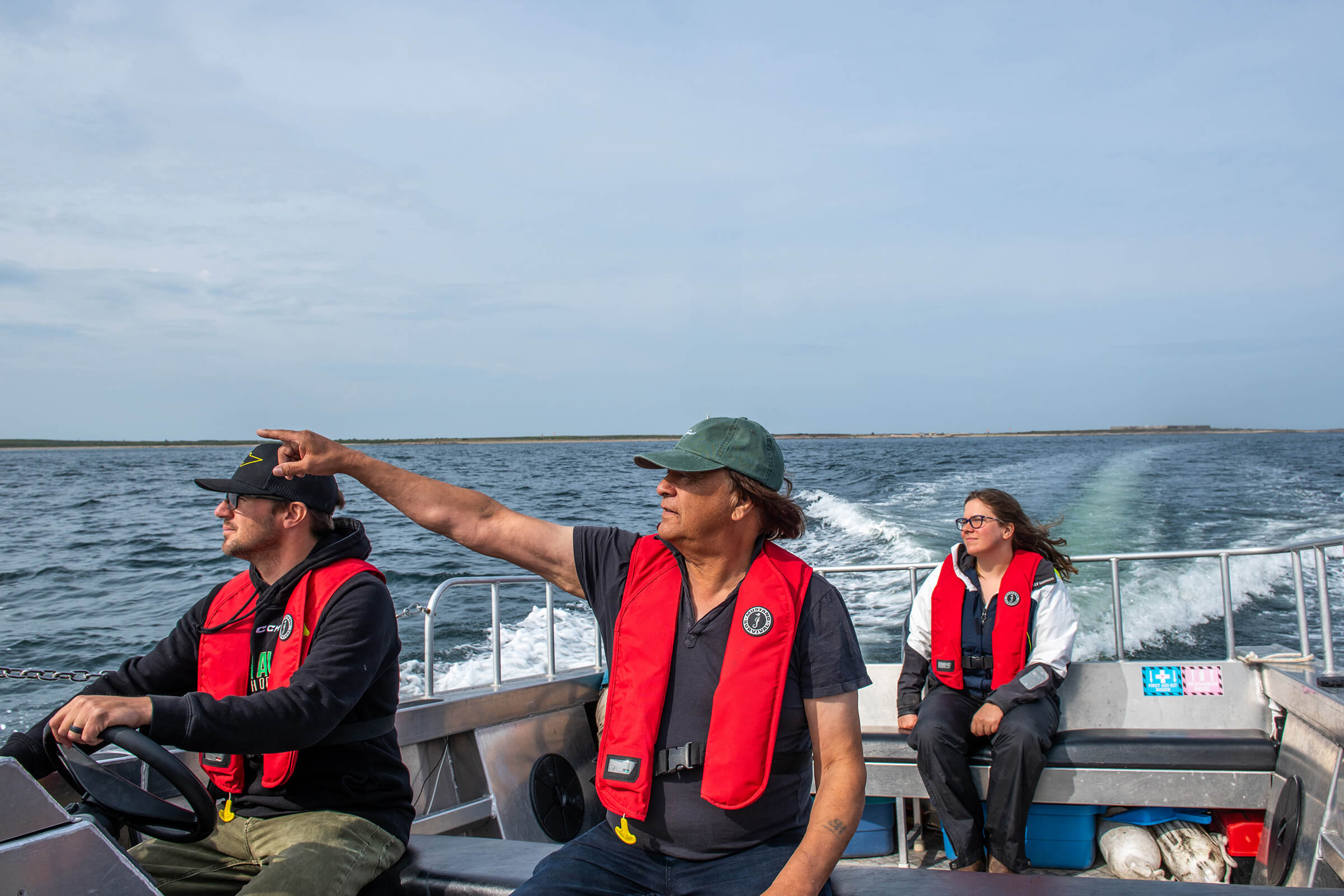 Brendan McEwan (left), an ecotourism company provider and the President of the Churchill Chamber of Commerce, and Mayor Michael Spence travel the Churchill River estuary with CMO Research Coordinator Emma Ausen [BSc/2018, MSc/2022], whose UM graduate student research looked at beluga whale behavioural patterns in response to boats and environmental conditions