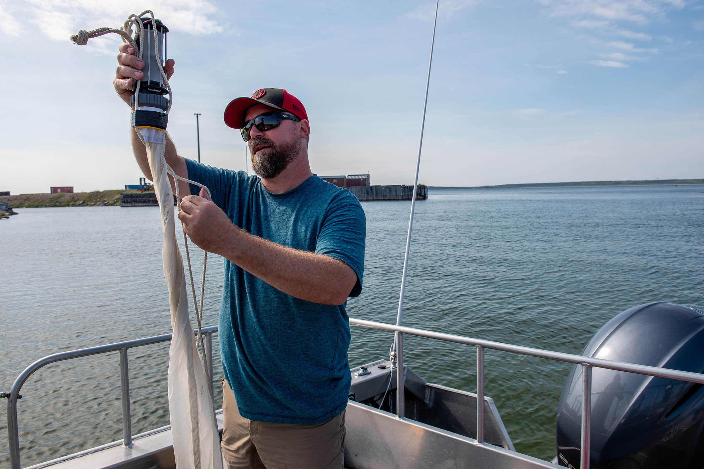 Oceanographer C.J. Mundy prepares for water sampling on the Churchill River estuary. Aboard the much larger William Kennedy, he lowers in heavy-duty equipment for measurements at various depths across Hudson Bay