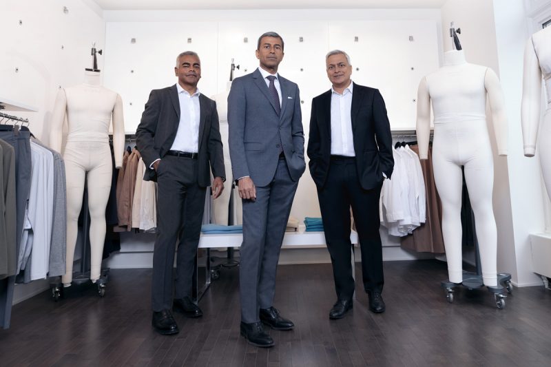 Raj Bahl, Ash Modha and Prashant Modha stand among clothing racks and mannequins in their retail space