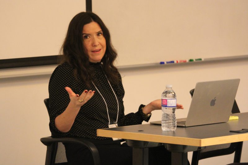 Seated at a desk, Dr. Chelsea Gabel speaks.