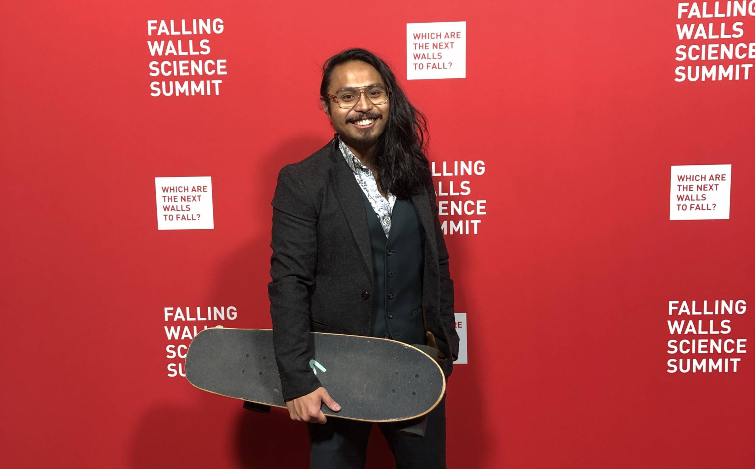 Nolan De Leon holds his signature skateboard on the red carpet at the Falling Walls Lab in Berlin.