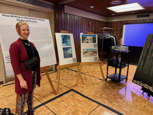 Student standing with research poster display. 