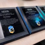 Three award plaques sit on a table.