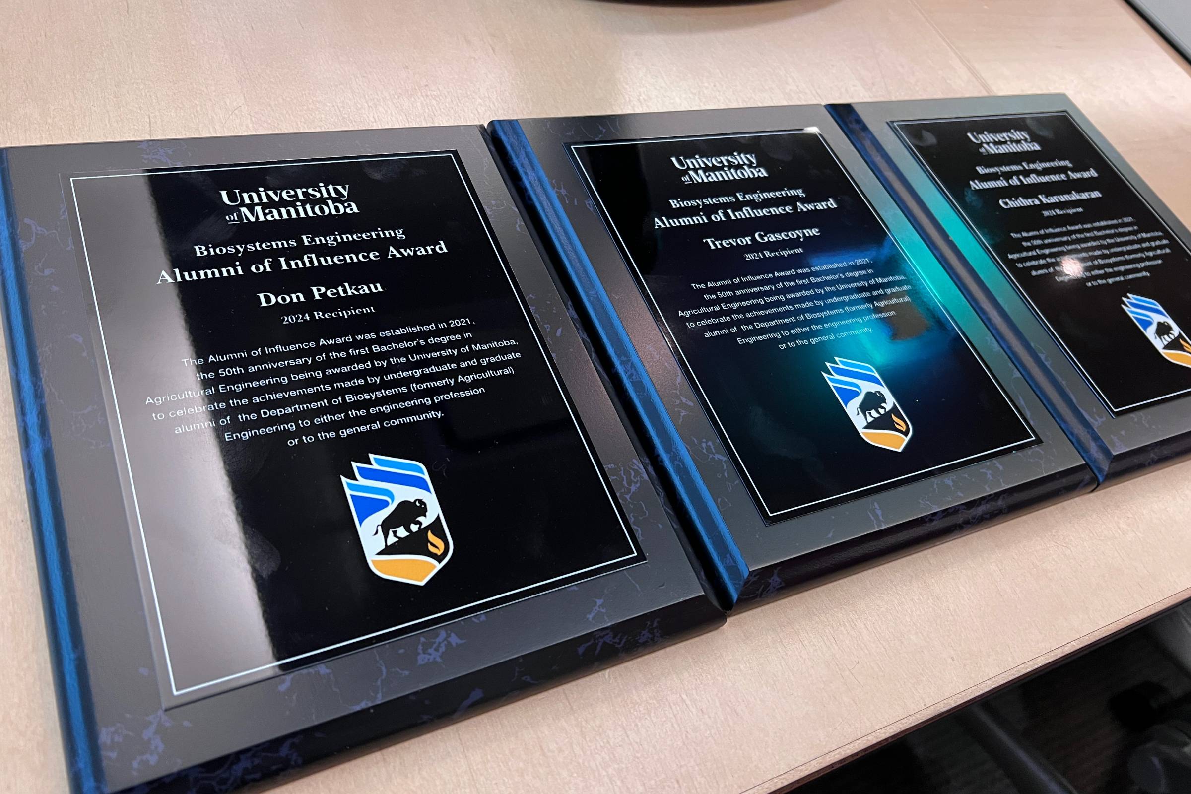 Three award plaques sit on a table.