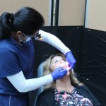 A oral pathologist examines the inside of a patient's mouth.