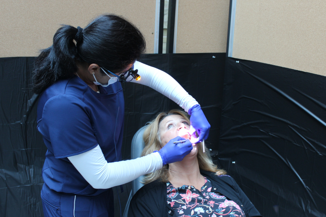 A oral pathologist examines the inside of a patient's mouth.