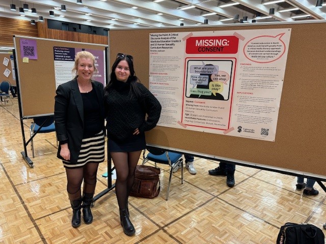 Student standing with research poster display. 