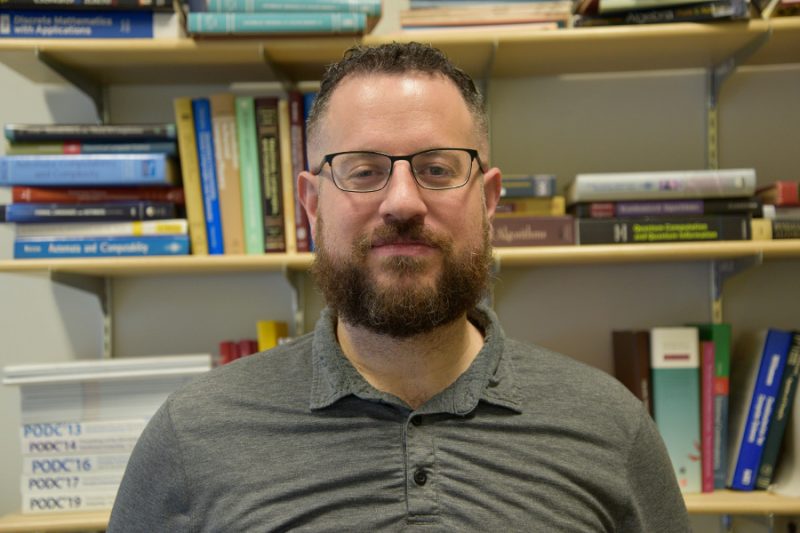 Dr. Avery Miller with a book case in the background.