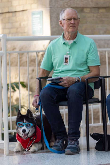 George Ames with therapy dog Hero on stage at the College of Pharmacy awards ceremony.