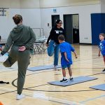 Jasmine Brar leading children in a yoga session at the Rady Kids' Club, University of Manitoba, helping them enjoy physical activity while their parents study.