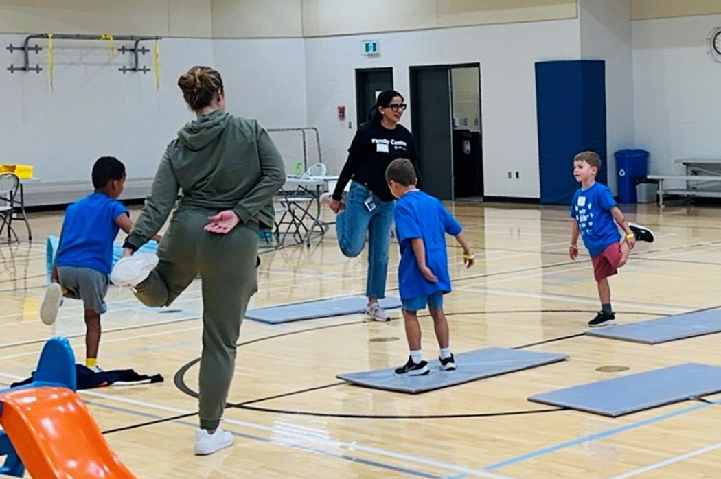 Jasmine Brar leading children in a yoga session at the Rady Kids' Club, University of Manitoba, helping them enjoy physical activity while their parents study.