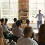 Photo of a presenter speaking in front of a group of people