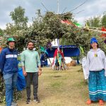 Three students stand in front of a sundance lodge.