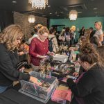 Shoppers browsing a student-vendors collection of bead work at the Indigenous Winter Market