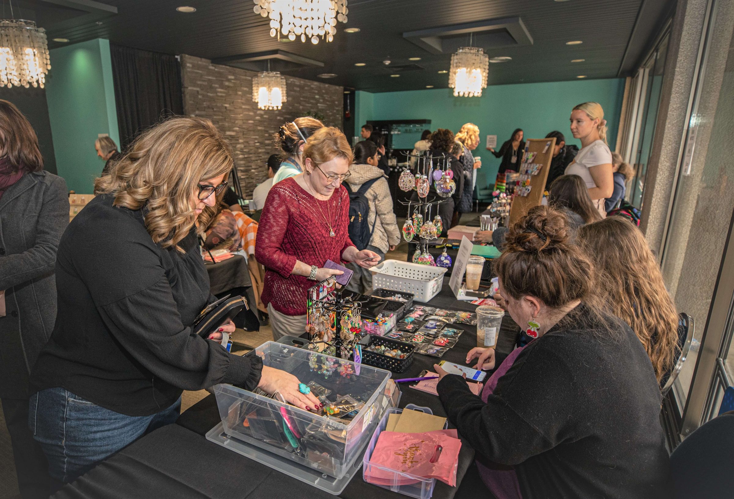 Shoppers browsing a student-vendors collection of bead work at the Indigenous Winter Market