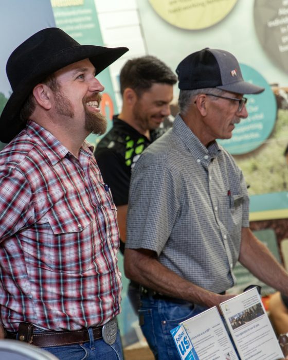 3 Manitoba producers enjoy an information display