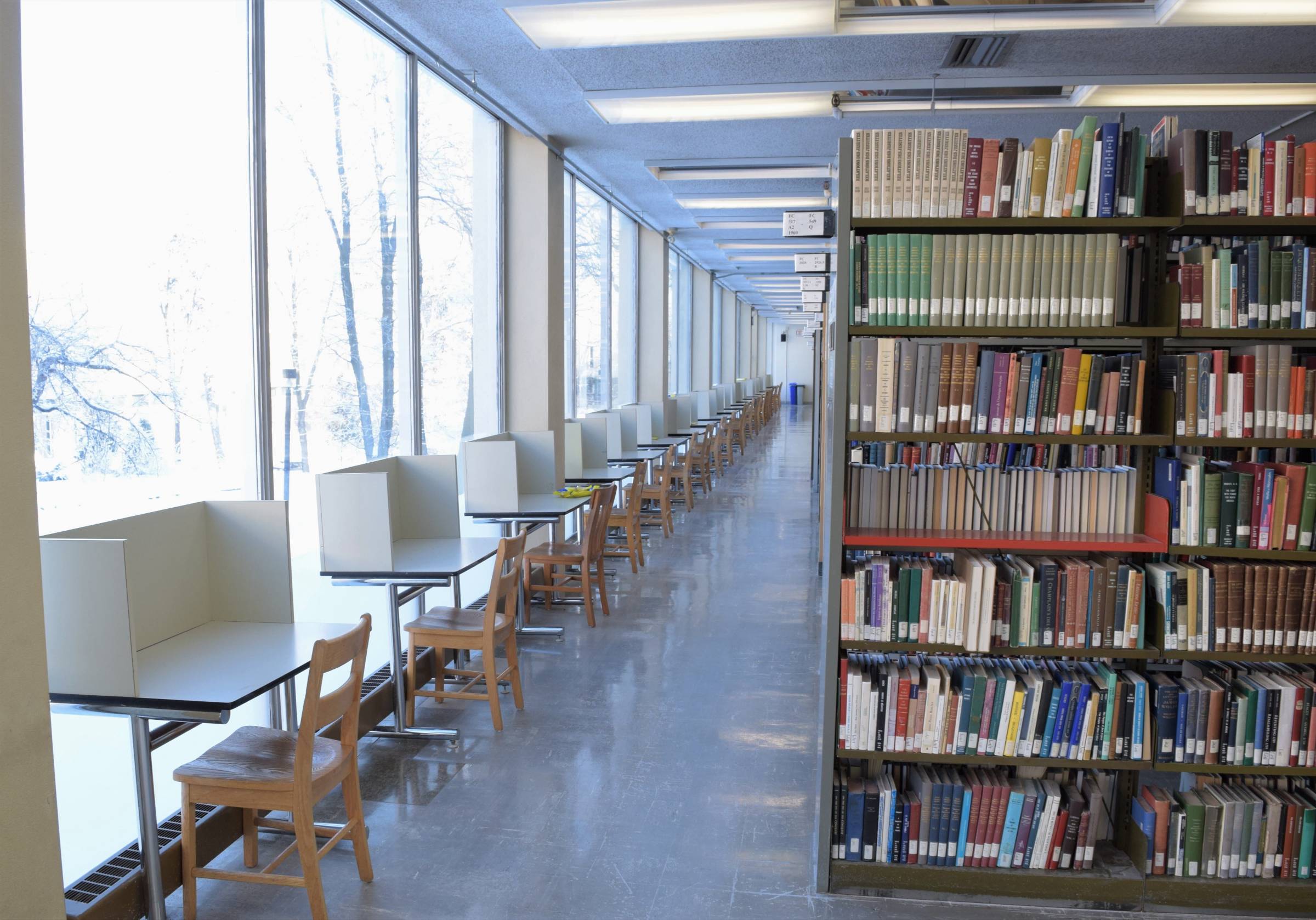 Rows of study carrels and bookshelf at Elizabeth Dafoe Library