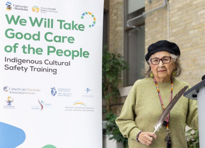 Elder Margaret Lavallee holds an eagle feather at the launch of the training program.