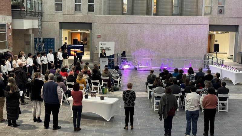 An audience of people facing a speaker at a podium