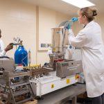 Two technicians work on equipment in a lab in the Richardson Centre.