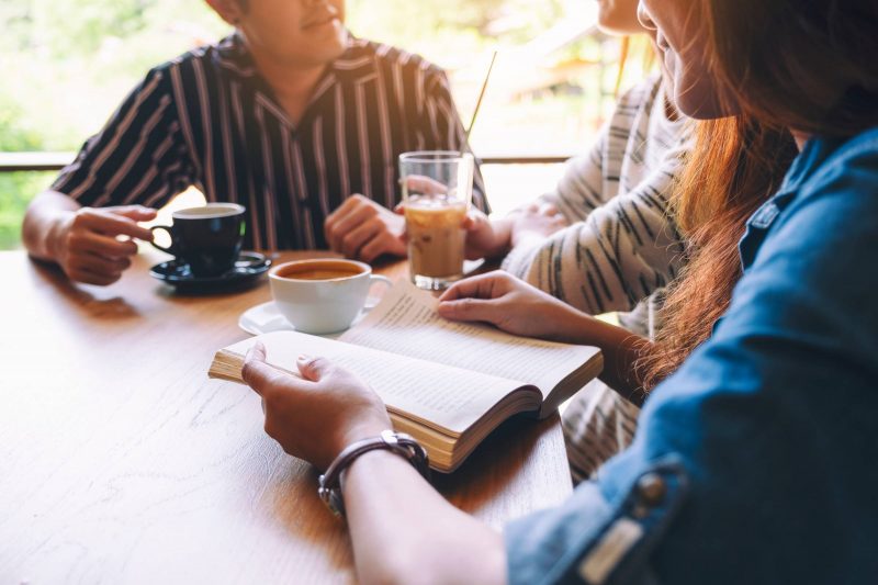 Student readin group with coffee and books