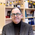 Dr. Peter Nickerson in his office smiling with graphic of lights around the frame