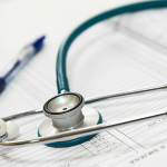 Stethoscope and a pen on a patient chart.