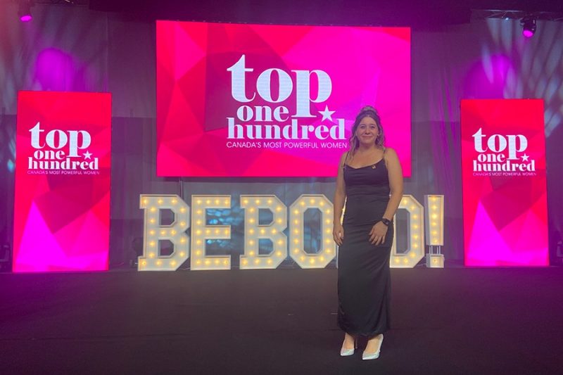 Dr. Melanie Lalonde at the WXN award ceremony standing in front of the BEBOLD sign.