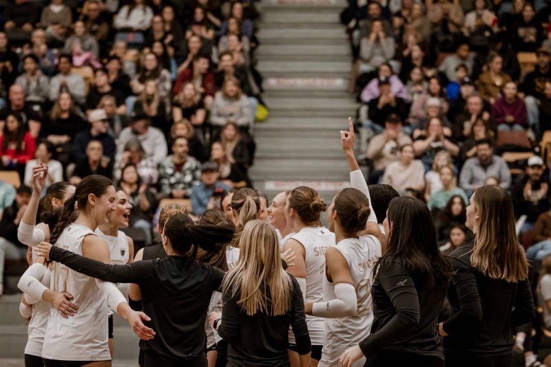 Bisons women's volleyball team waves to the crowd after a game