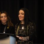 Two women speaking at a podium
