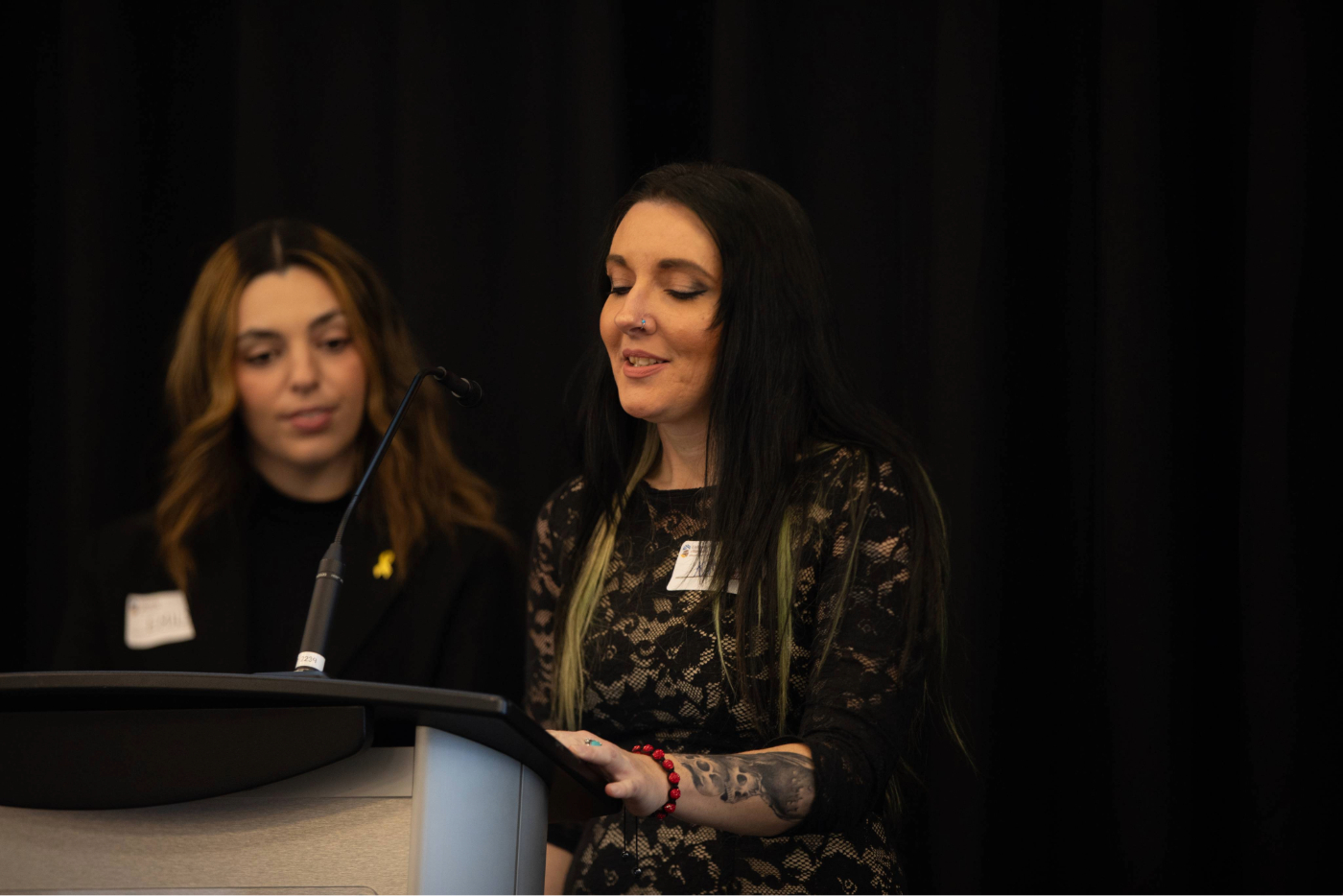 Two women speaking at a podium