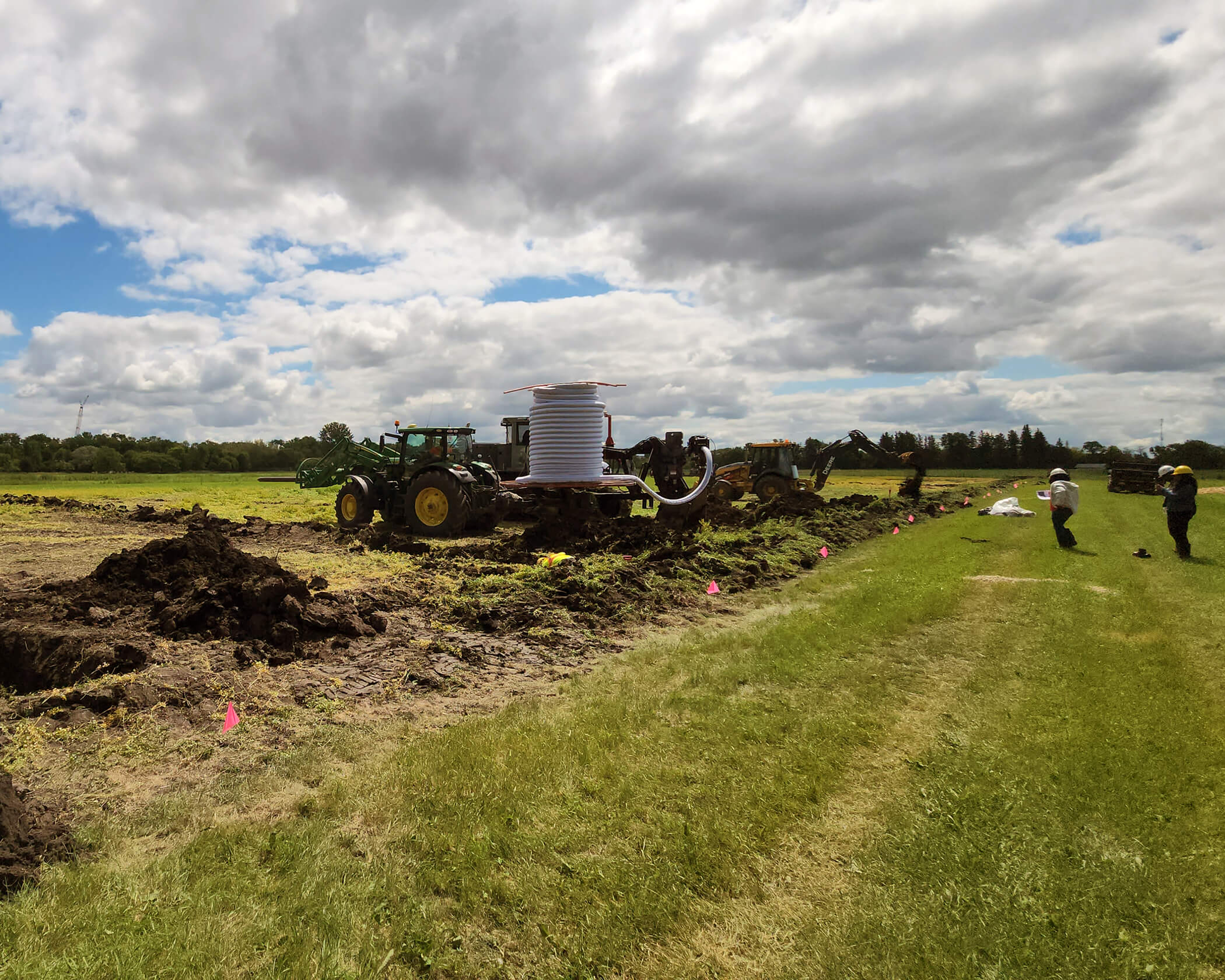 People with tractors conduct research on drainage