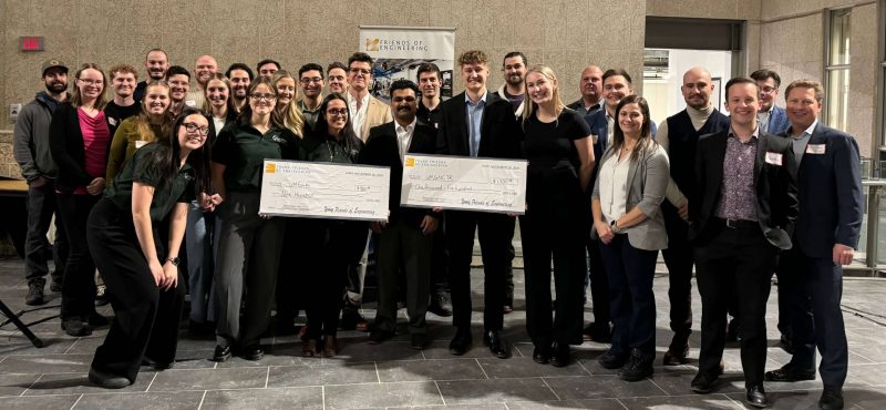 A group of people holding large novelty cheques