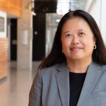Dr. Hope Anderson, in a hallway, smiles at the camera.