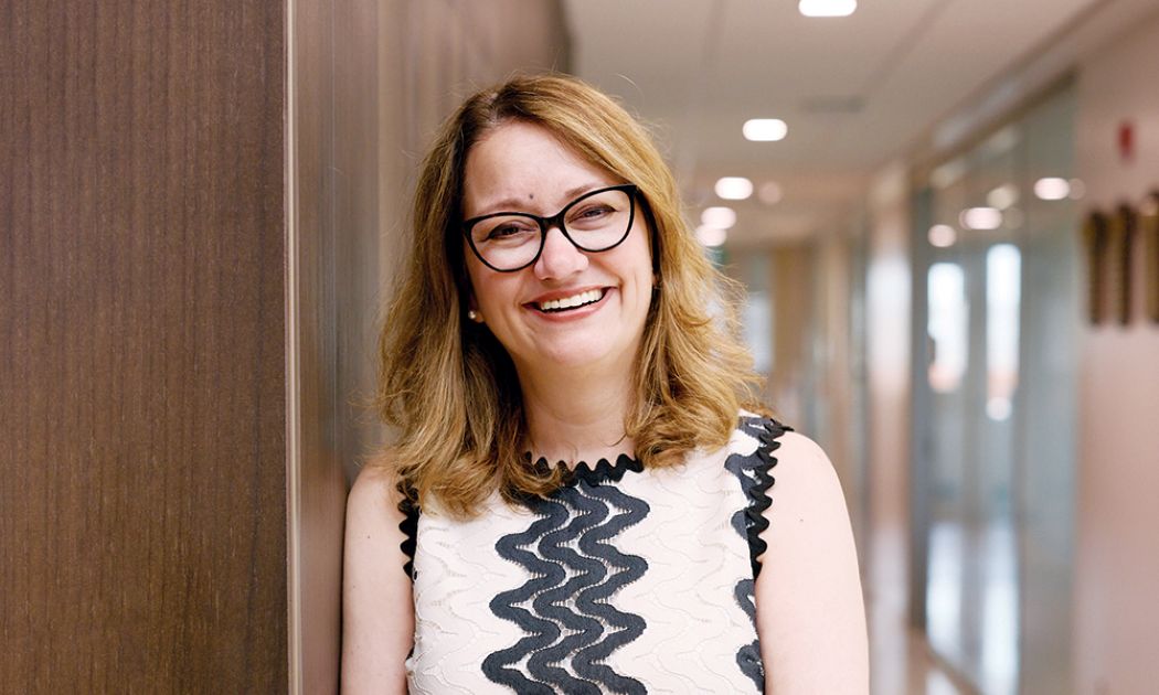 Dr. Sarah Forgie stands in a hallway.