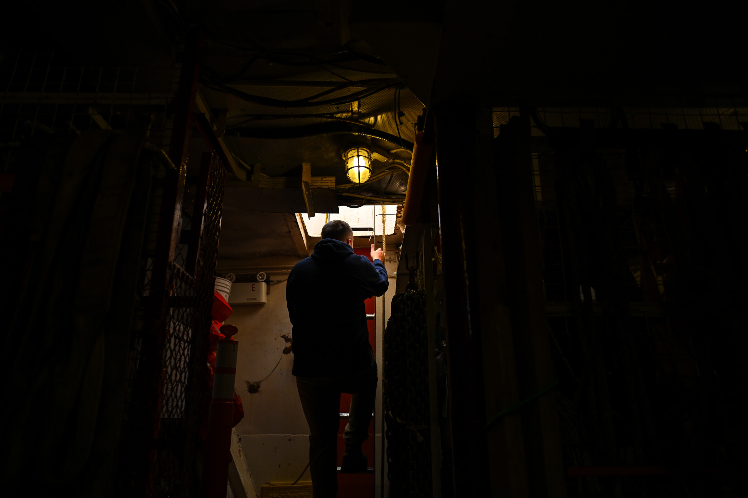 Riley Versluis, whose work focuses on fish, climbs up from the bowels of the ship.