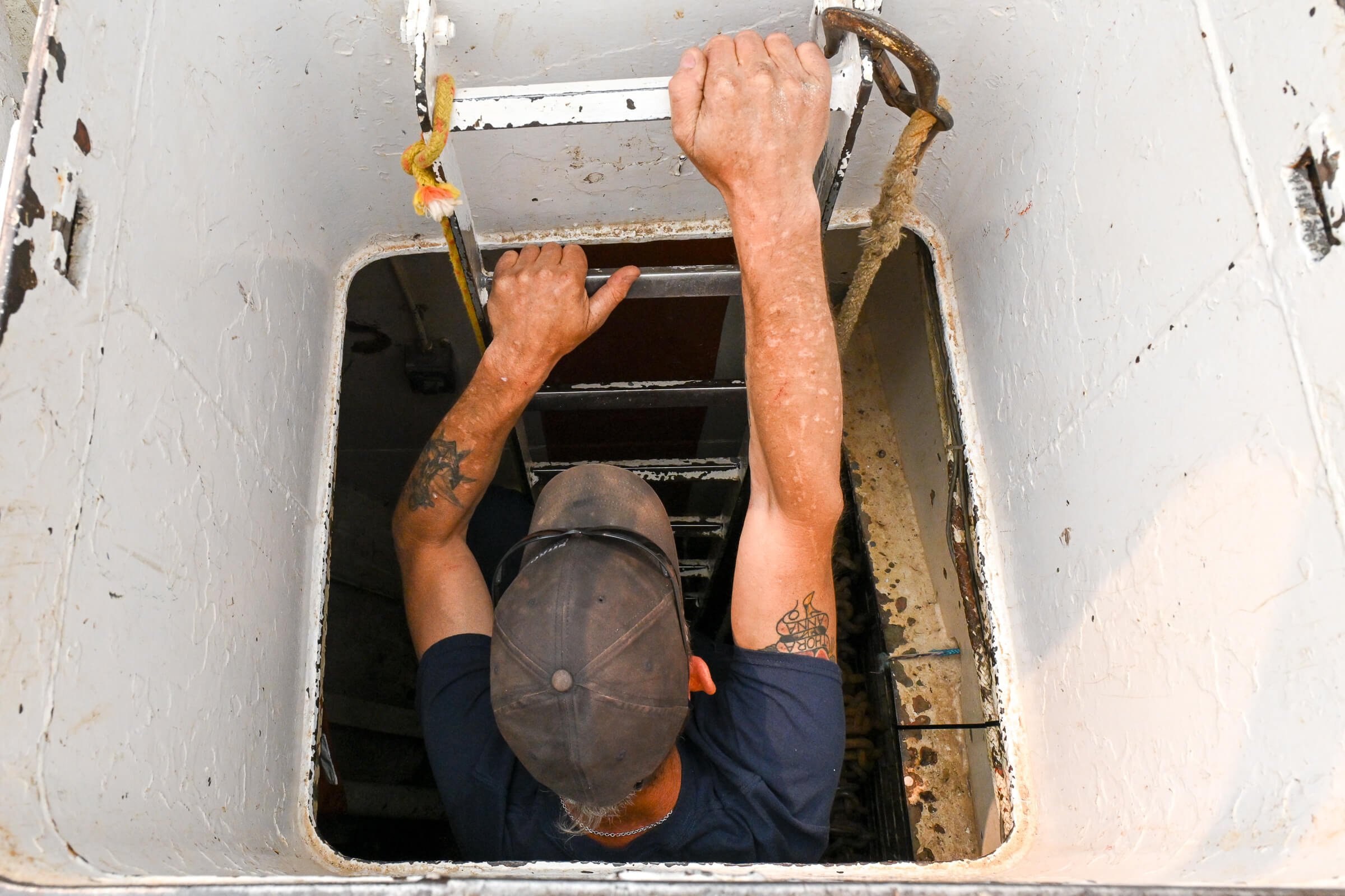 Kevin Palson, a crane operator on the Namao research vessel, climbs up through an opening
