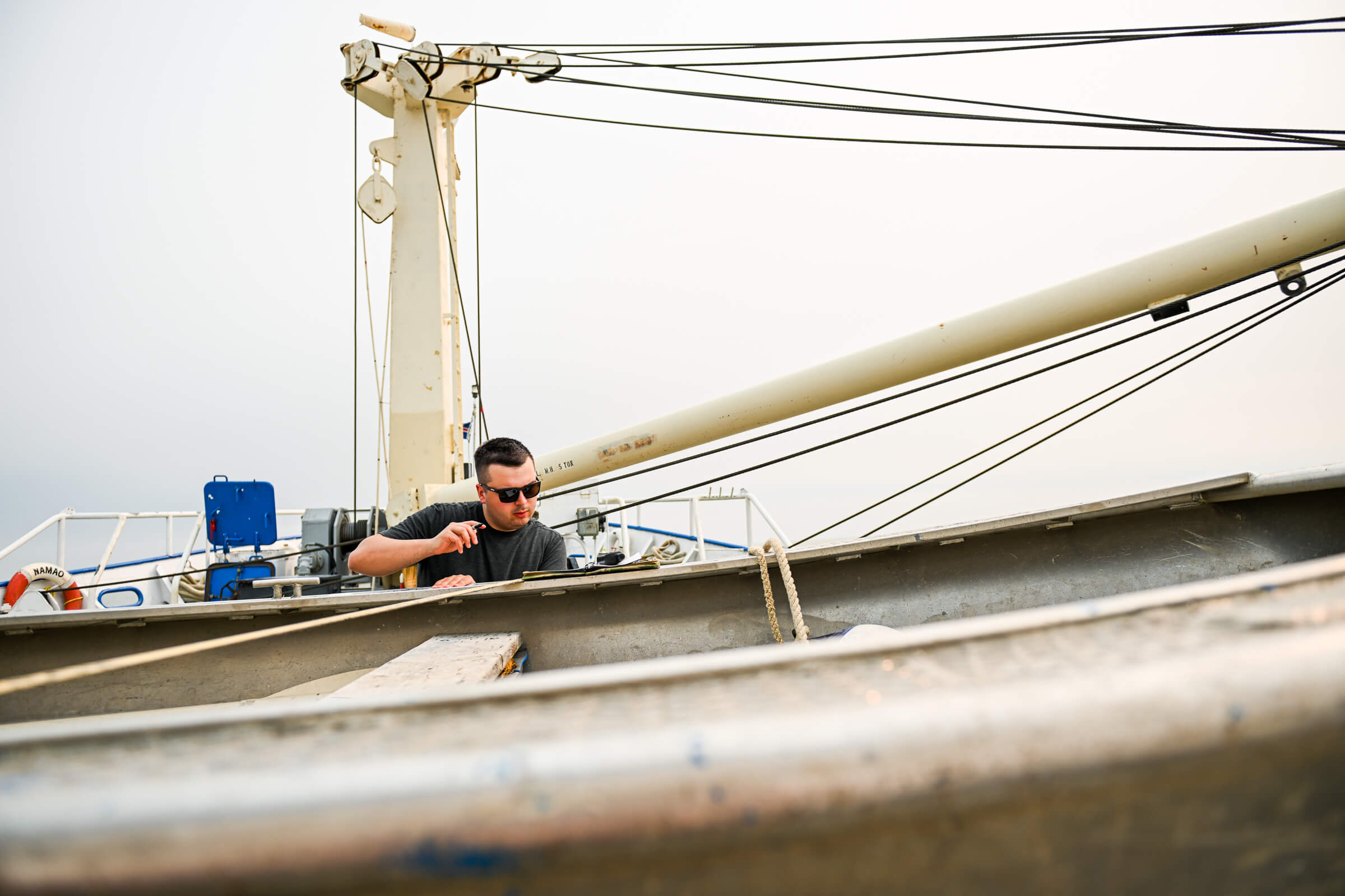 Riley Versluis, science coordinator aboard Namao research vessel, takes notes