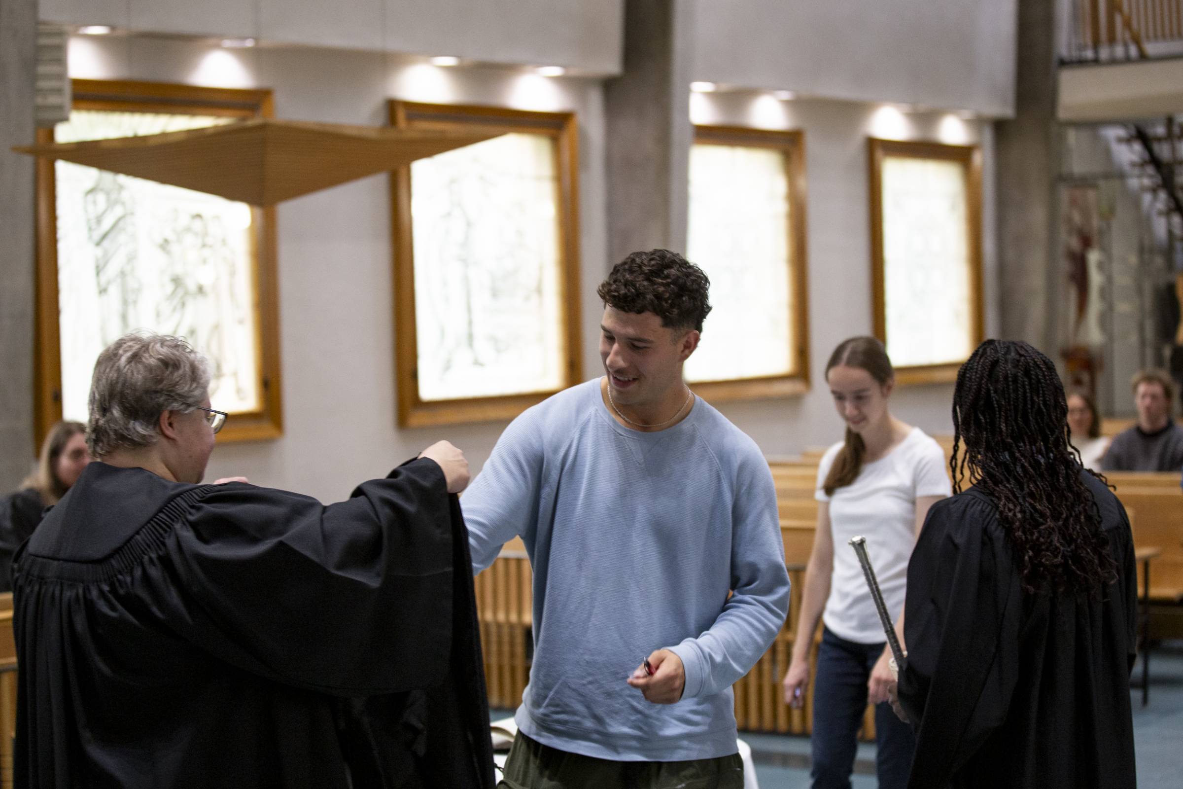 student member putting on their robe after signing the matricula