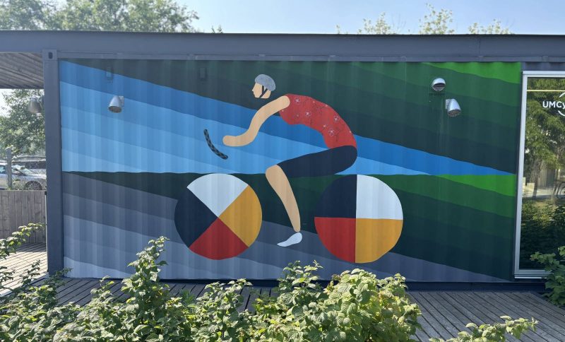 Mural of cyclist with medicine wheels